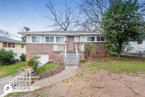 a brick house with a front yard and stairs