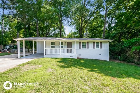 a small white house with a lawn and a porch