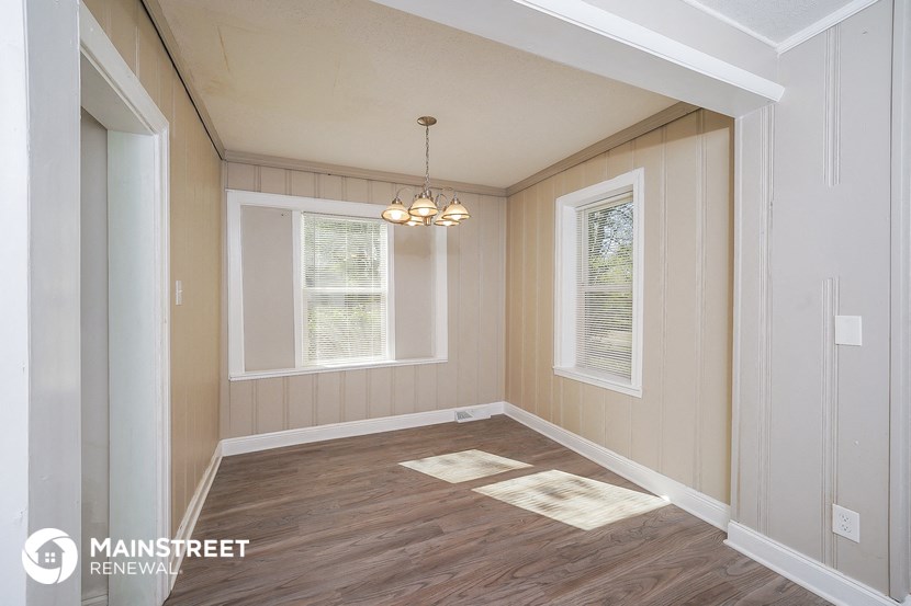 a dining room with wood floors and a chandelier
