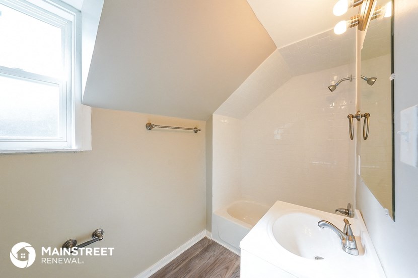 a bathroom with a sink and a tub and a window