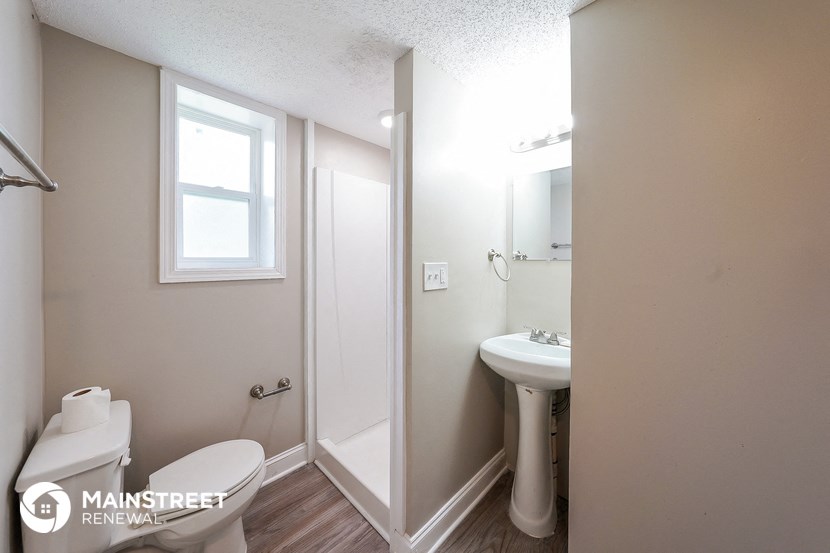 a bathroom with a toilet and a sink and a shower