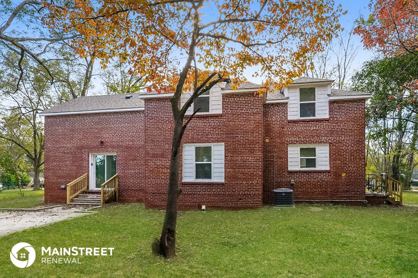 a brick house with a tree in front of it