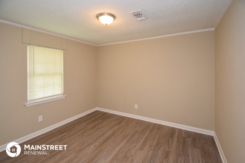 the interior of an empty room with wooden floors and a window
