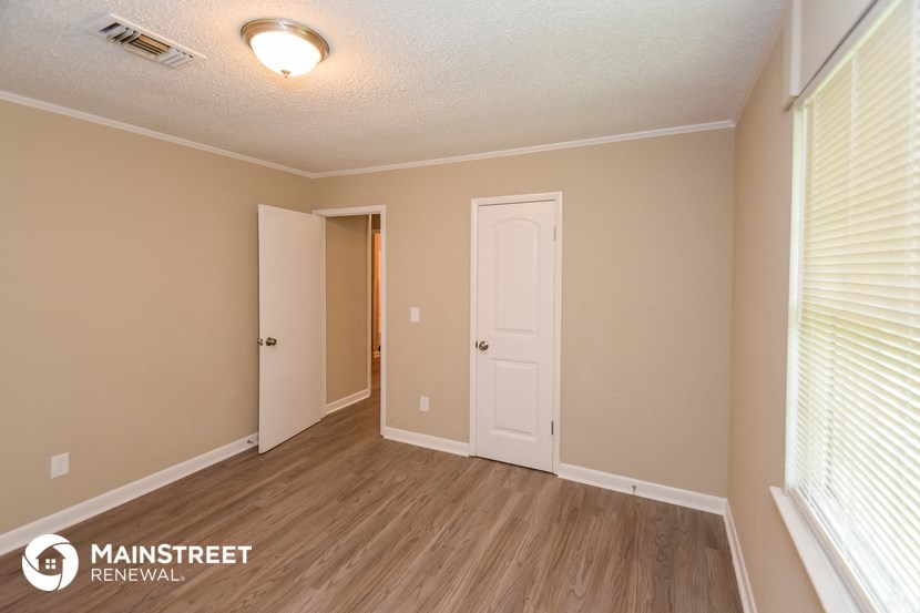 the upstairs bedroom with a door to the closet and a window