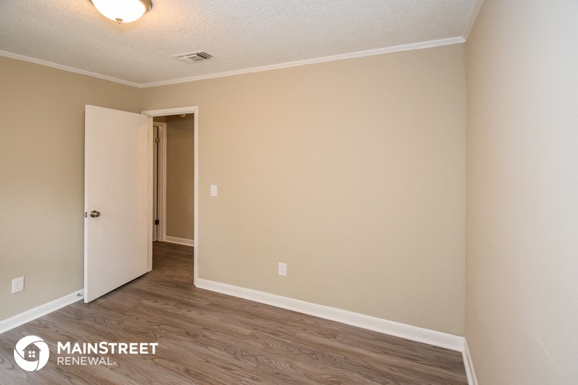 the interior of an empty room with white walls and wood flooring