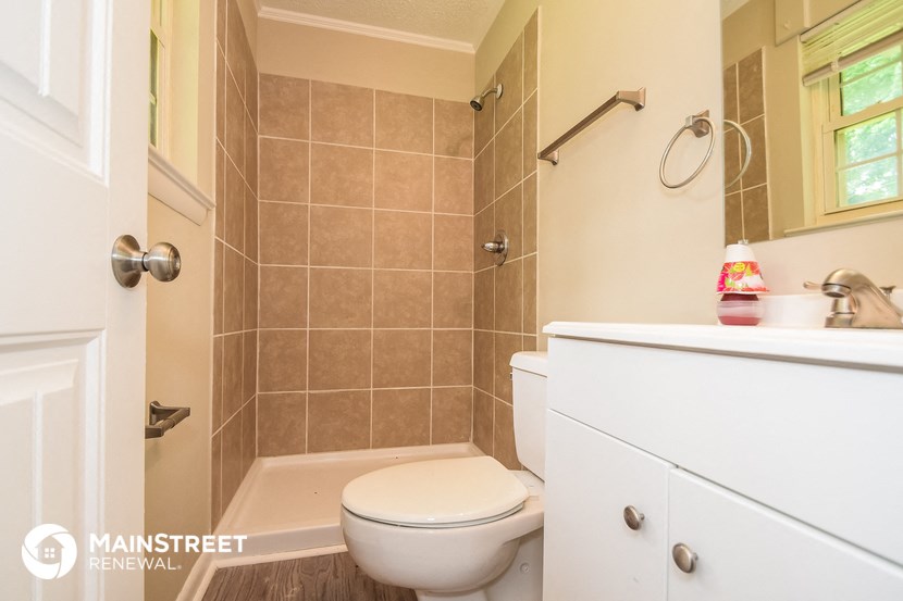 a bathroom with a toilet and a shower and a sink
