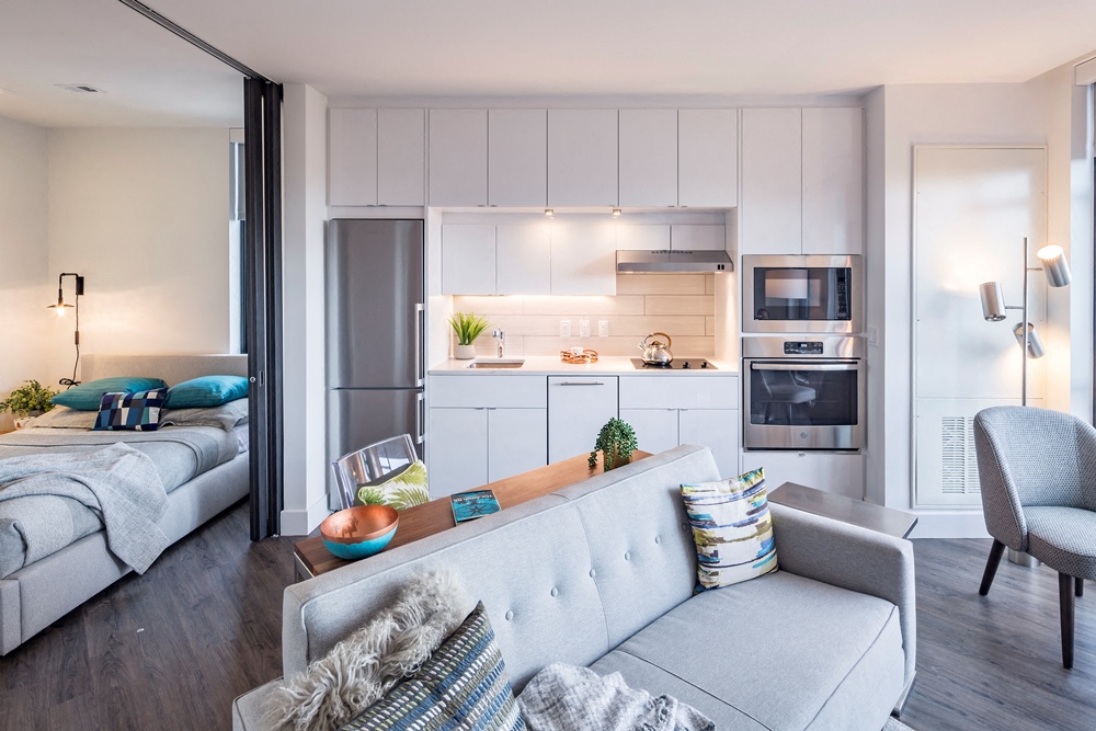 a living room with a couch and a kitchen