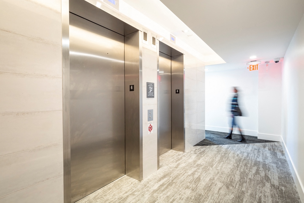 a person walking through a lobby with elevators