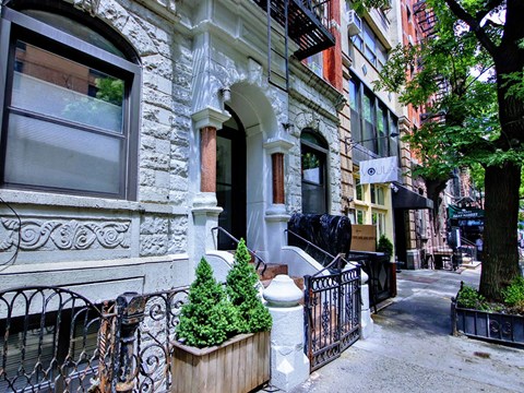 a building on a city street with trees in front of it