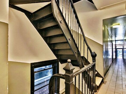 a staircase in a house next to a hallway with a door