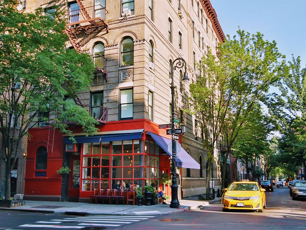 a yellow taxi parked in front of a building on a city street