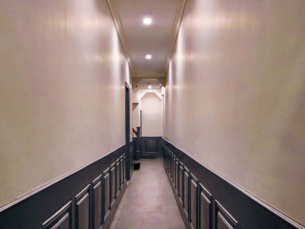 a long hallway with black railings and white walls