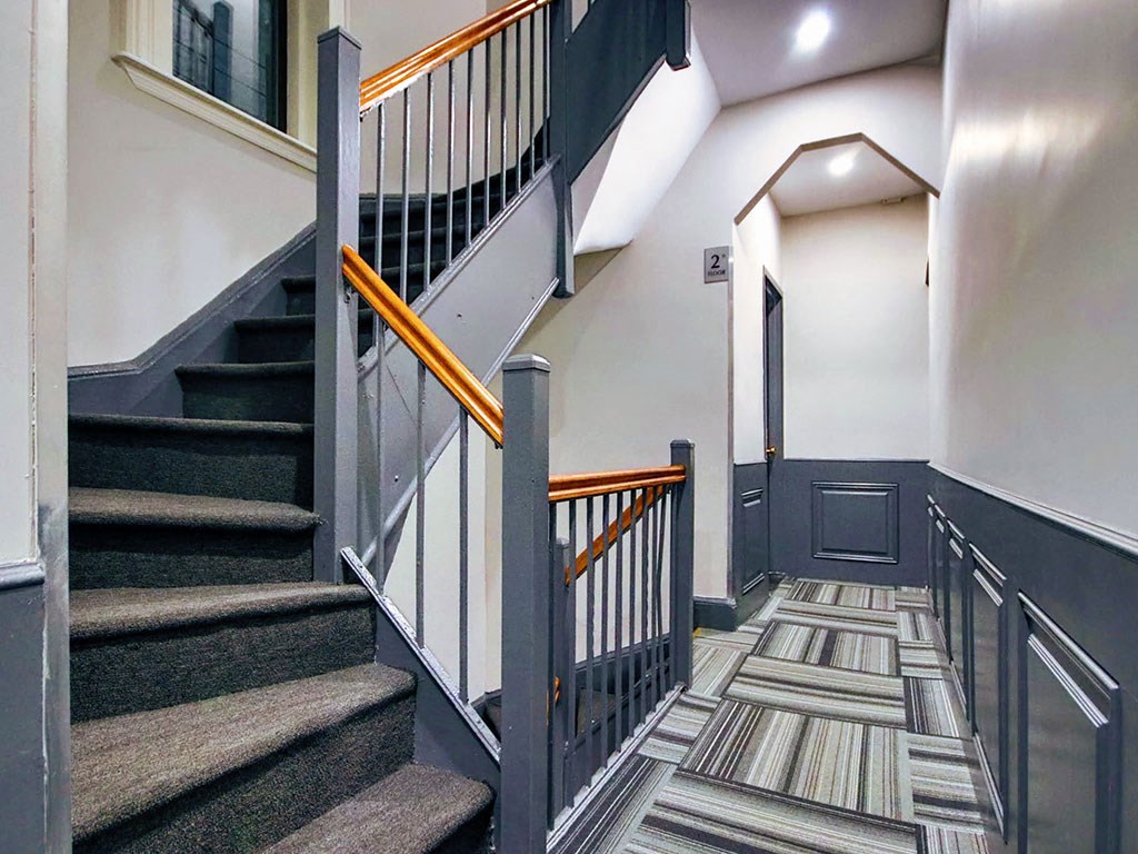a staircase in a home with carpeted stairs and a door