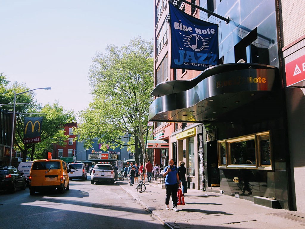 a busy city street with people walking on the sidewalk