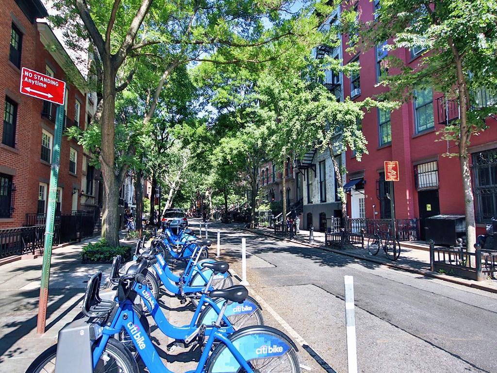a row of blue bikes parked on a city street