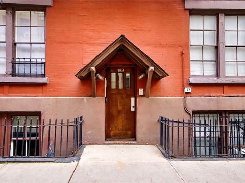 an orange building with a wooden door and windows