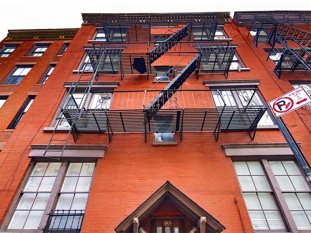 a red brick apartment building with fire escapes