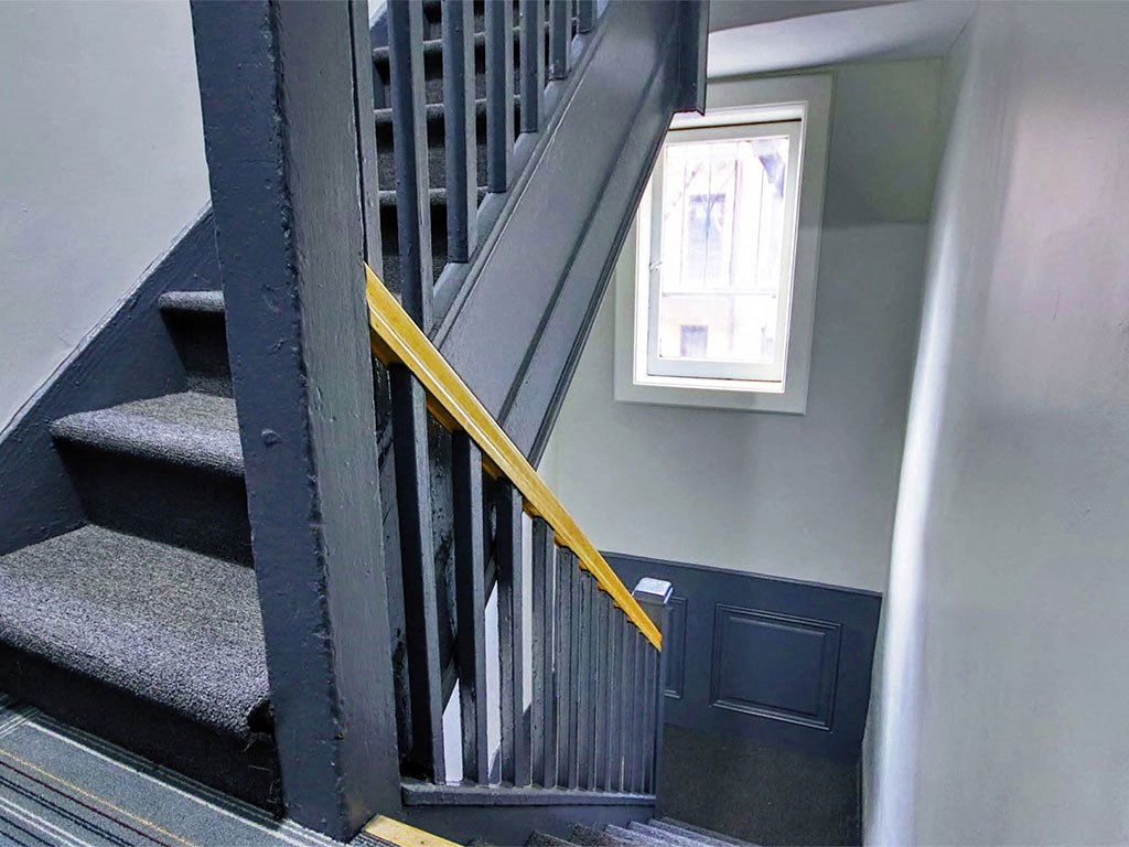a staircase with a metal railing and a window