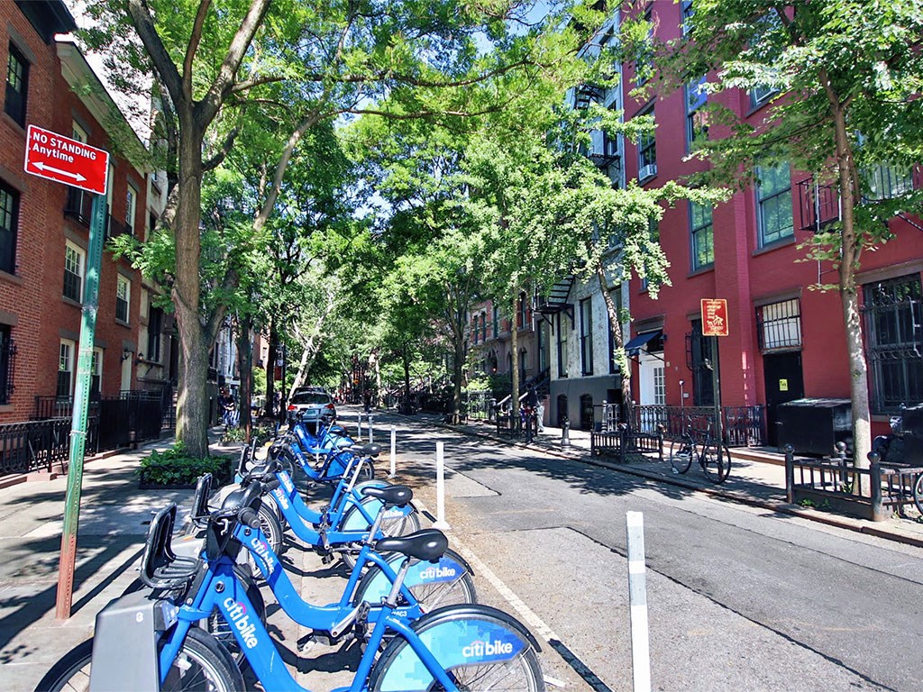 a row of blue bikes parked on the side of a street