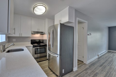 a kitchen with stainless steel appliances and white cabinets