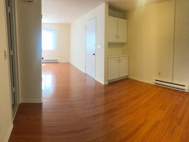 an empty living room with a hard wood floor