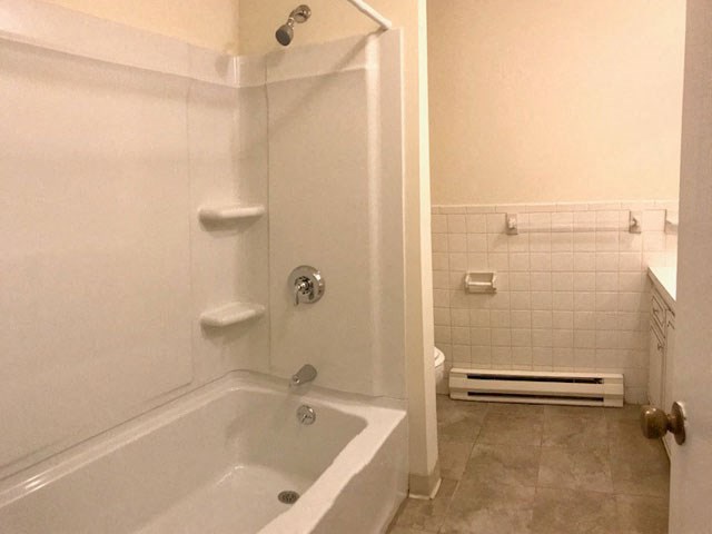 a white bathroom with a tub and a shower
