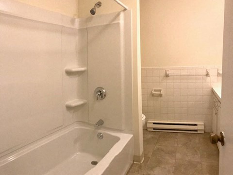 a white bathroom with a tub and a shower