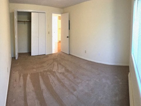an empty living room with white walls and a rug on the floor