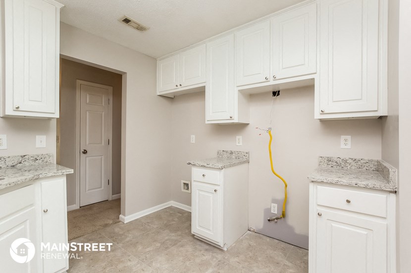 a white kitchen with white cabinets and white counter tops