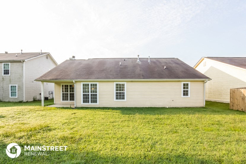a small white house with a yard in front of it