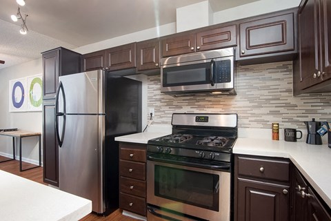 a kitchen with stainless steel appliances and wood cabinets