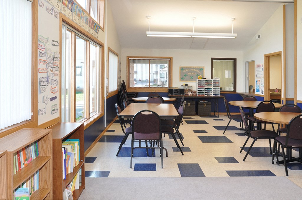 a classroom with tables and chairs in a library