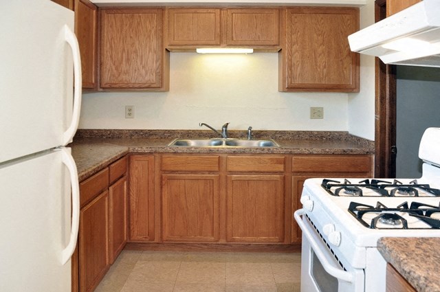 an empty kitchen with a stove and a sink