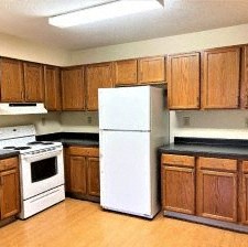 a kitchen with wooden cabinets and a white refrigerator