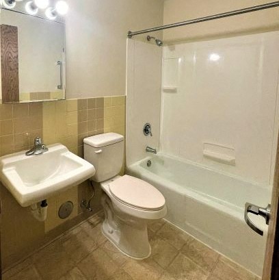 a bathroom with a toilet and a sink and a tub