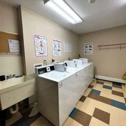 a laundry room with four sinks and a sink and a tub