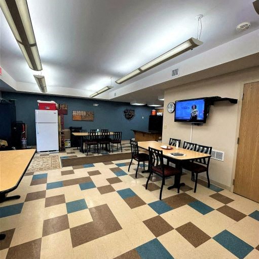 a dining room with tables and chairs and a tv