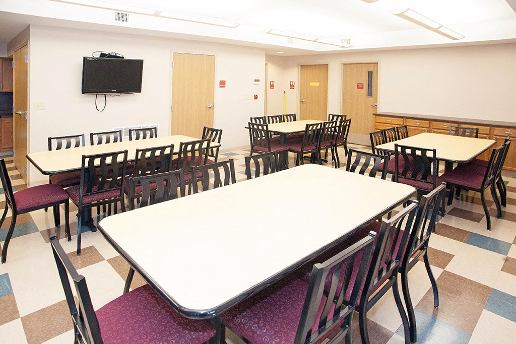 a dining room with tables and chairs and a tv