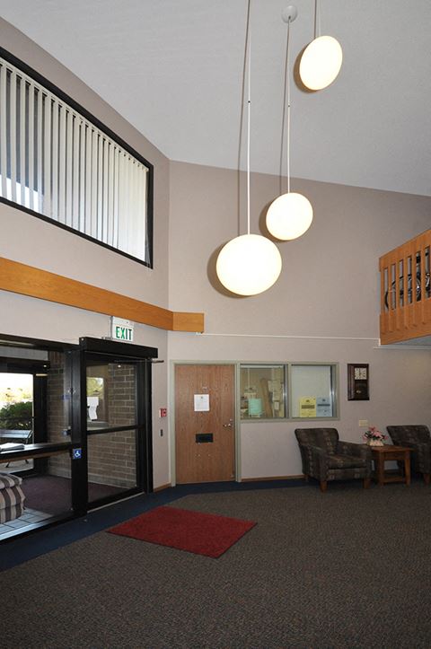 a view of the lobby of a hall with three lights and a door