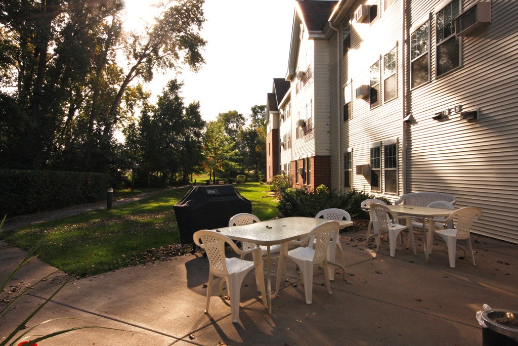 a patio with tables and chairs in front of a house