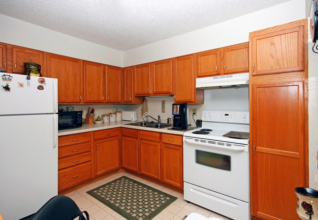 a kitchen with white appliances and wooden cabinets