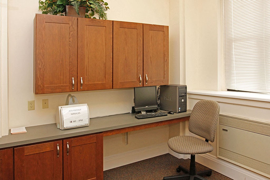 a desk with a chair and a computer on it