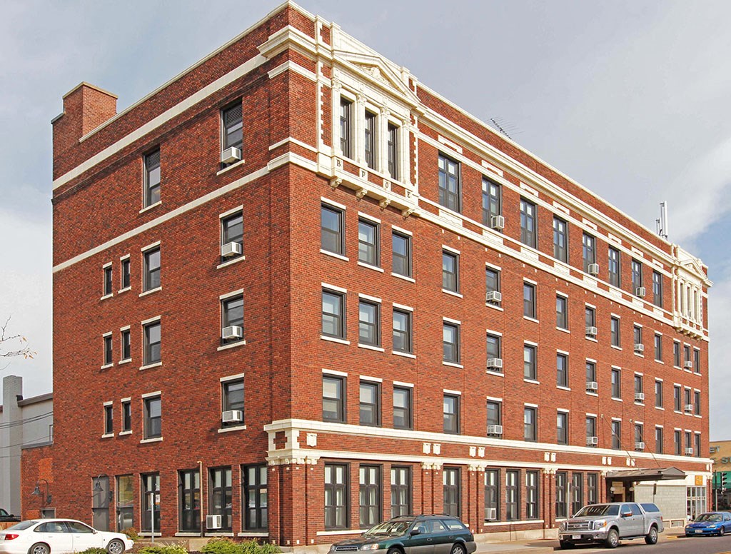 a large red brick building with cars parked in front of it