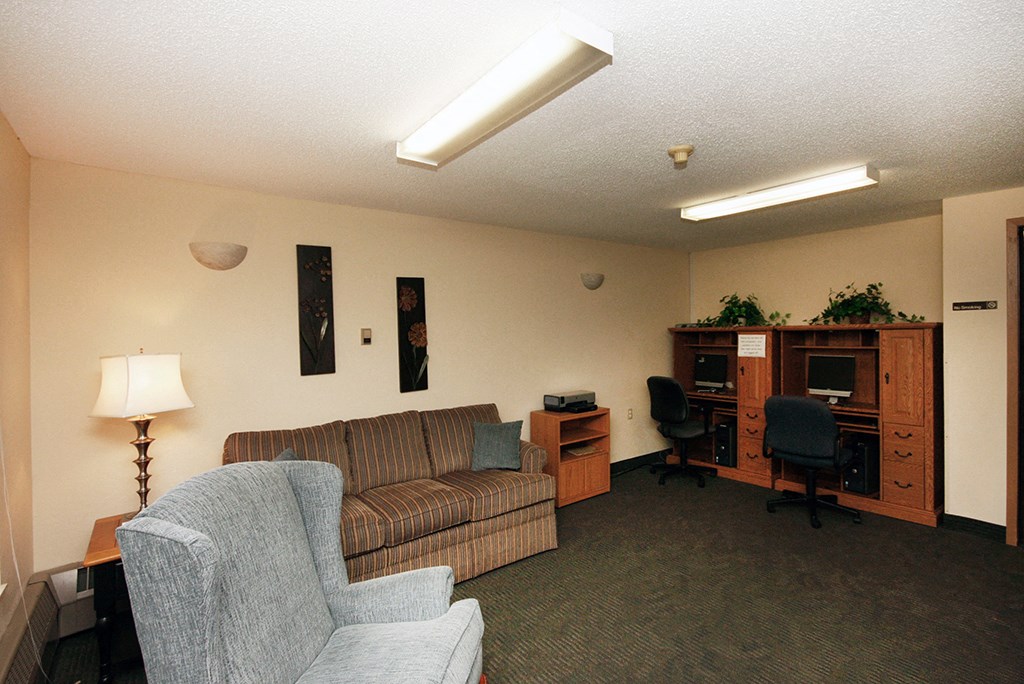 a living room with a couch and chairs and a tv