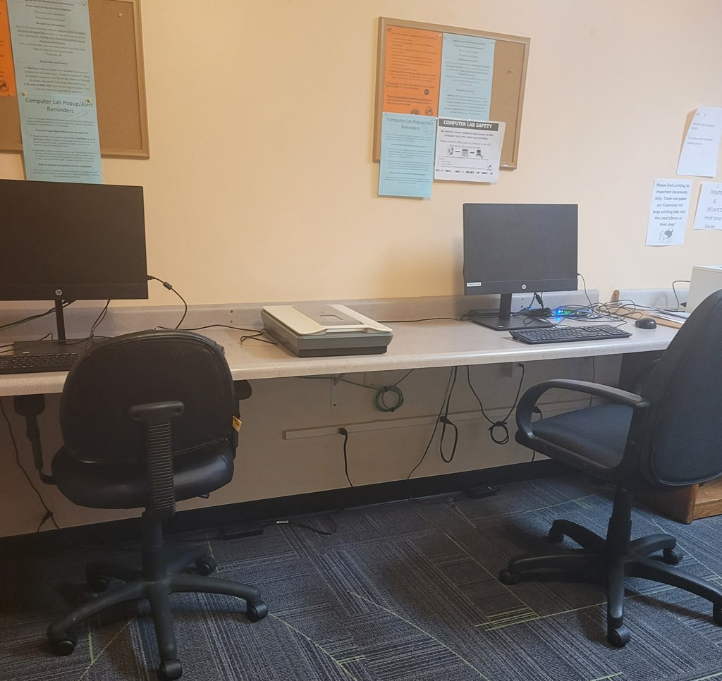 a computer desk with two monitors and a keyboard on it