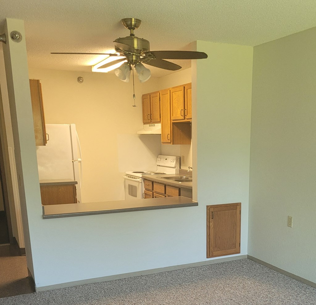 a view of a kitchen through a mirror with a ceiling fan