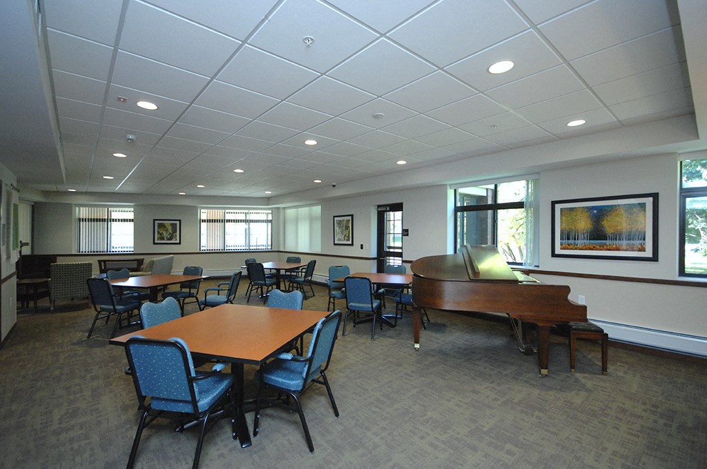 a room with tables and chairs and a piano