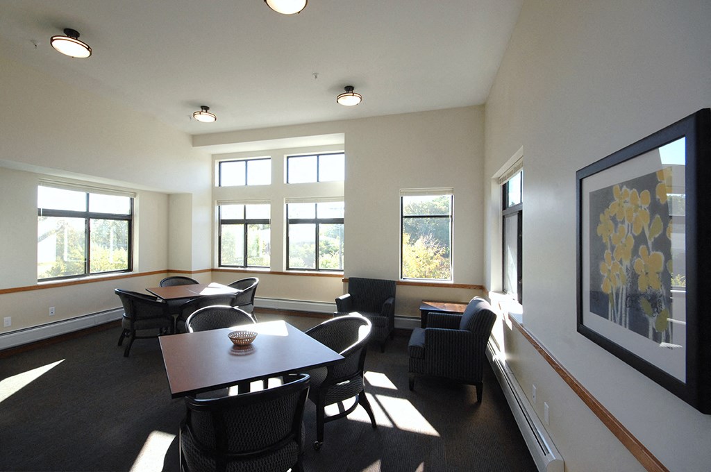 a room with a table and chairs and a large window