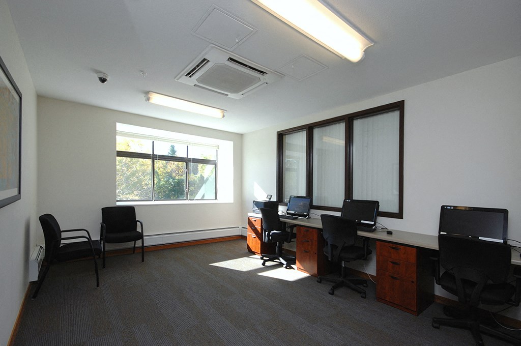 an office with desks and chairs and a window