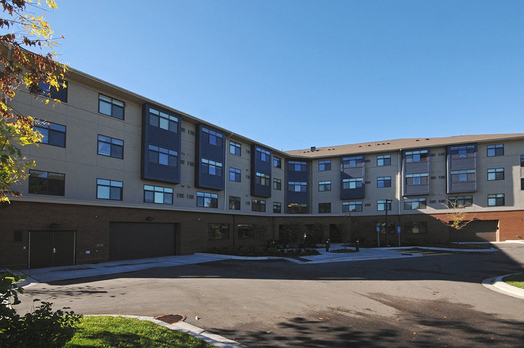 an exterior view of an apartment building with a parking lot